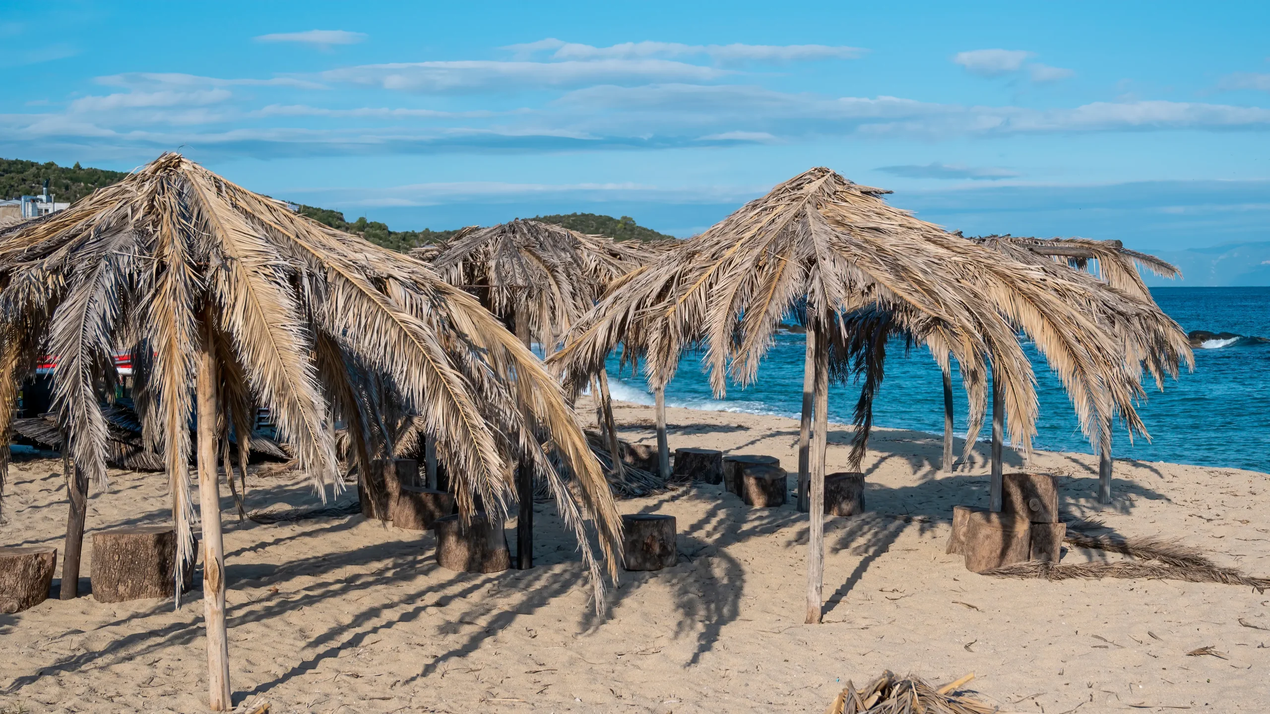 playa-del-mar-egeo-con-sombrillas-hechas-de-ramas-de-palmera-en-grecia